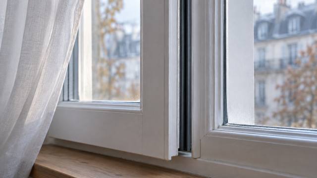 Fenêtre blanche entrouverte avec joint d’étanchéité visible sur le dormant