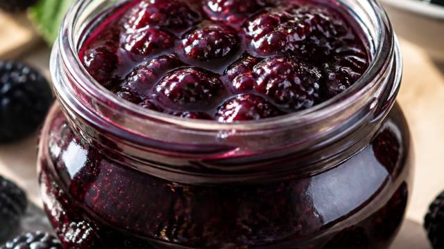 Pot de confiture de mûres entouré de mûres fraîches