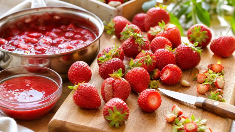 Fraises triées avec une compotée et un coulis dans une cuisine lumineuse