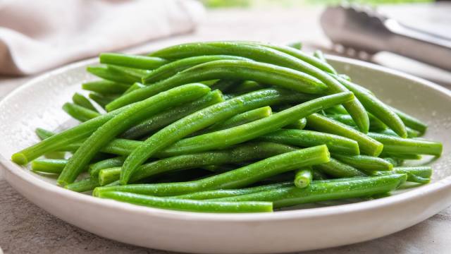 Haricots verts frais cuits et brillants dans un plat clair