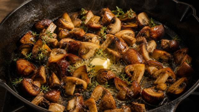 Poêlée de champignons dorés au beurre et au thym dans une poêle en fonte
